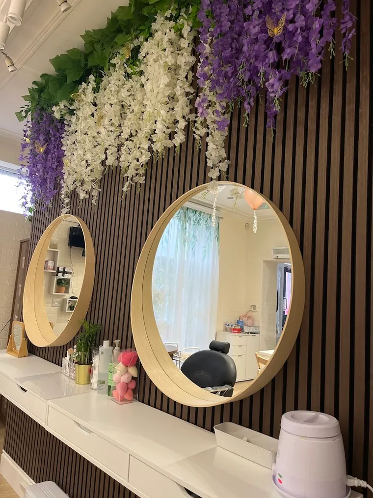 Inside Shriji Beauty Touch — the round mirrors and wisteria wall on Trinity Street